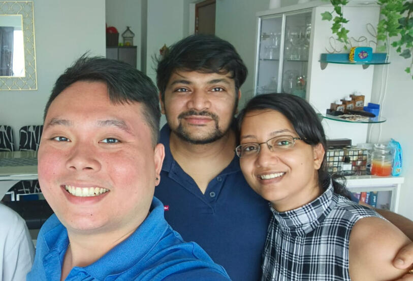 Alvin smiling in a photograph with a client couple.